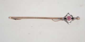 A 9ct gold and silver bar brooch set with a pink stone. Marked 9ct and Sil. Tests 9ct and silver.