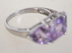 A hallmarked 9ct white gold and trilogy amethyst ring.
