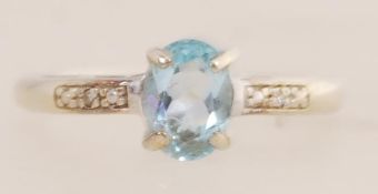 A 9ct gold ring set with diamonds and a central blue stone. Size L. Tests 9ct gold.