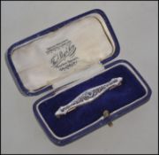 A boxed 14ct gold bar brooch with filigree decoration set with central blue sapphire with saftey