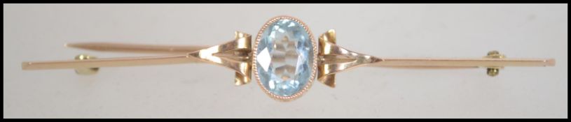 A 15ct gold bar brooch set with a single oval cut aquamarine stone set within a pierced gallery