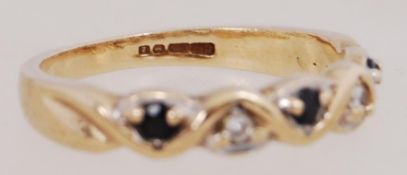 A 9ct gold ring set with sapphire and diamonds withing a wave form. Hallmarked Birmingham. Size M.5.