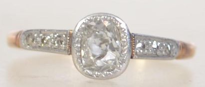 An 18ct gold and diamond ladies ring having diamond set shoulders surrounding the oval old cut