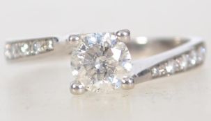 A 585 marked 14ct white gold diamond solitaire ring with diamond channel set shoulders .
