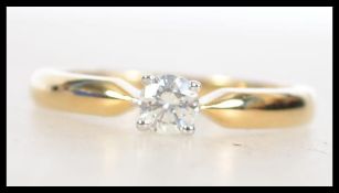 An 18ct gold diamond solitaire ring having a suspe