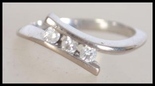 An 18 ct white gold cross over ring with 3 diamond
