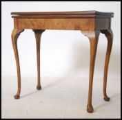 An Edwardian walnut card table cross banded with R