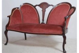 An Edwardian mahogany inlaid spoon back conversation sofa settee having shaped legs with pad feet.