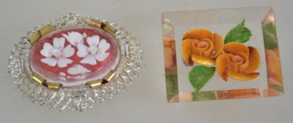 Two 1950s carved Lucite brooches one being of square form with inset orange flowers having a brass