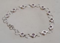 A silver 925 bracelet with lobster claw clasp having faceted amethyst stone spacers. Weighs 10.7