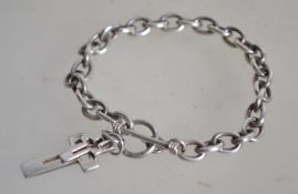 A silver rolo link bracelet with toggle fastening and a double crucifix charm. Both marked 925.