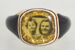 A 1940s celluloid hand made prison ring having a small photo of a woman and child on a background of