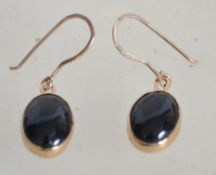 A pair of tested 9ct gold earrings with onyx cabochon drops. Weighs 3.12 grams. Unmarked but tests