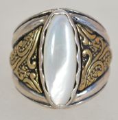 A silver 925 ladies oversized dress ring having central oval moonstone and textured yellow metal