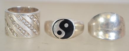 A group of three silver 925 rings to include a silver signet ring, a band ring with diagonal paste