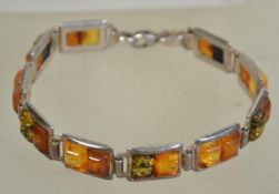 A silver 925 panel bracelet with interlocking rectangular lozenges with amber type coloured stones