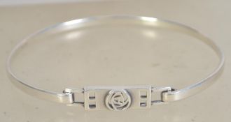 A silver 925 bangle bracelet of oval form having a hidden clasp and Celtic knot symbol to front.