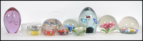 A collection of glass paperweights to include milliefiori cane work, control bubble, flower,