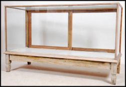 A 1930's stripped oak shop haberdashery display shop counter being raised on sqaured legs with glass