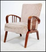 A 1930's Art Deco bentwood fireside armchair being raised on square supports with chenille