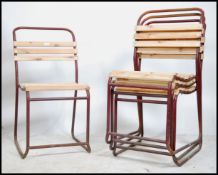 A stack of vintage mid century Industrial / school hall stacking chairs being raised on tubular