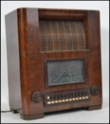 A vintage 1950's walnut cased HMV radiogram with decorative facia and set within a good shaped case