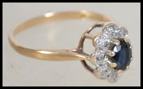 A 9ct gold hallmarked sapphire and diamond ring having a central oval sapphire stone with illusion