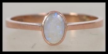 A 9ct gold and opal ladies ring. The central oval cut opal. Maker SA, Believed London hallmark being