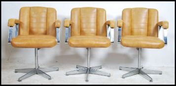 A set of three retro 20th century salon / barbers swivel chairs. Having a beige button back vinyl