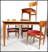 A mid century teak wood extending dining table and 4 chairs in the Danish style of Nathan Furniture.