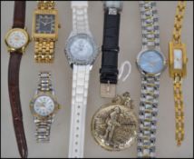 A group of watches to include a gold tone metal pocket watch with a fisherman to front, a Lorus
