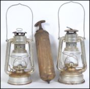 A pair of 20th century German made Tilly style storm lamps together with a vintage brass fire