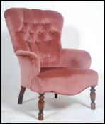 A Laura Ashley velour upholstered Victorian style armchair raised on turned legs with button