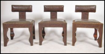 A set of three 20th century Moroccan carved hardwood leaher opium stools- dining chairs. Having a