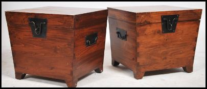 A pair of matching 20th century hardwood trunks / bedside chests. Having a hinged top opening to