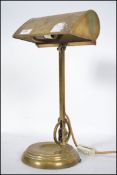 A vintage mid century brass bankers lamp raised on terraced base having angular and adjustable
