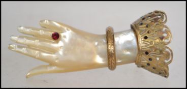 A 19th century Victorian mother of pearl hand brooch with ruby ' Ring ' decoration adorned with gilt