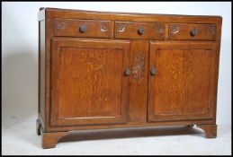 A 1930's Art Deco oak sideboard having embellished details to the front. The sideboard comprising