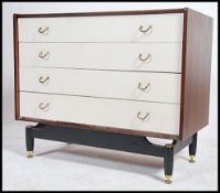 A 1970's retro teak and painted two tone G-Plan Librenza pattern chest of drawers being raised on an