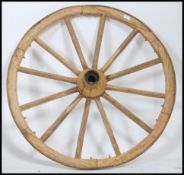 An early antique wooden cart wheel with iron hub and rim.  This wheel has had a lot of worm in the