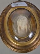 An early 20th century Grand Tour oval religious plaster intaglio, gilt frame carved with the