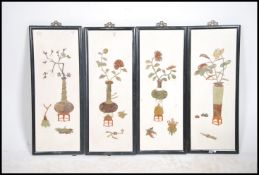 A group of four Chinese ceramic and marble framed plique a jour wall plaques each inlaid with a