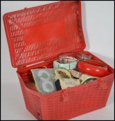 A vintage 1970's red plastic sewing box of picnic hamper form containing many items of costume