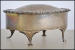 A silver hallmarked ladies dressing table footed trinket pot of oval form with hinged top raised