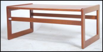 A 1970's retro teak wood rectangular coffee table raised on squared supports with chamfered edges