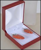 A ladies silver and apple coral drop earrings set. The coral of lozenge form with applied silver
