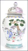 A large Chinese famille rose lidded vase decorated with scenes of peony tree's and birds with finial