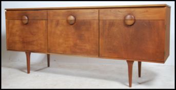 A 1970's retro Danish inspired teak wood sideboard being raised on tapered legs with a series of