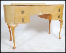 A 1930's kidney shaped Queen Anne writing table being raised on cabriole legs with pad feet having a