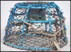 A large 20th century Devon sea fishing lobster / clawfish pot having net and rope present in blue